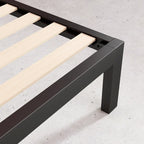Struttura letto a piattaforma in metallo nero con doghe in legno